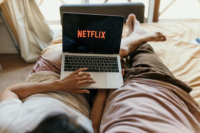 Netflix stock slides after Warner deal, analysts turn cautious, regulatory risks loom, and markets debate long-term upside.