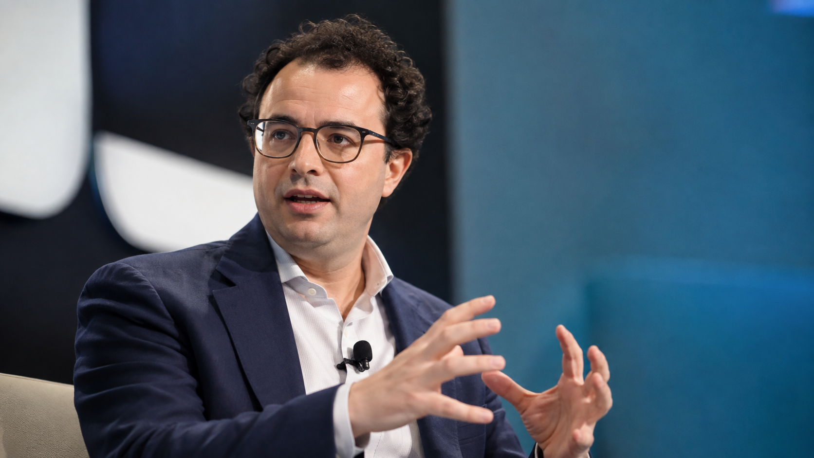 Anthropic CEO Dario Amodei speaks during a technology event, gesturing as he discusses artificial intelligence.